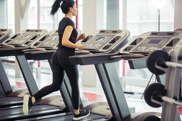 Mujer en forma joven corriendo en la cinta de correr — Foto de Stock