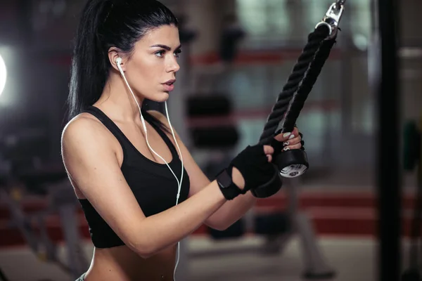 Femme faisant de l'exercice à la machine crossover dans la salle de gym — Photo