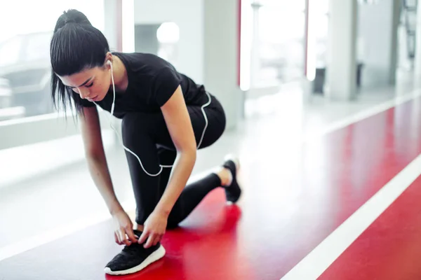 Nő kötött cipőfűző fitness tornaterem futás előtt futópályán — Stock Fotó