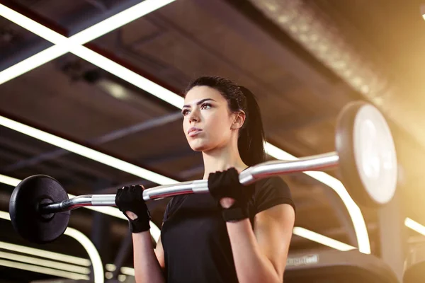 Fitness, Nahaufnahme einer jungen Frau, die im Fitnessstudio nach Bizeps greift — Stockfoto