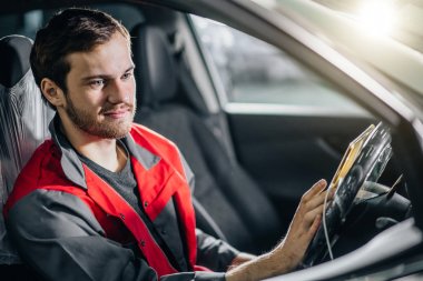 Mekanik oturan içinde araba arayan, dijital Tablet garajda