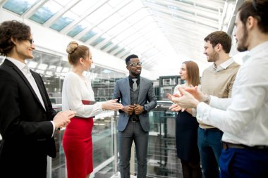 El sıkışan iki iş erkek meslektaşlarının applauding ve gülümseyen iken
