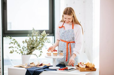yemek servis tabağı üzerinde meyveleri ile cupcakes dekorasyon genç sarışın ev hanımı