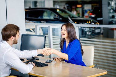 Satış Müdürü ve birbirlerine Bayilik showroom tebrik el sıkışan kadın müşteri.