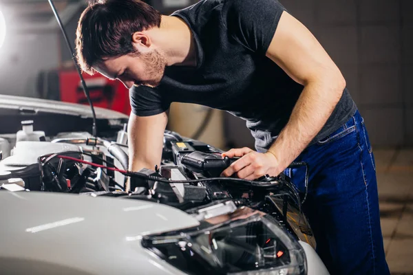 Mechanic testing electrical system on automobile — Stock Photo, Image