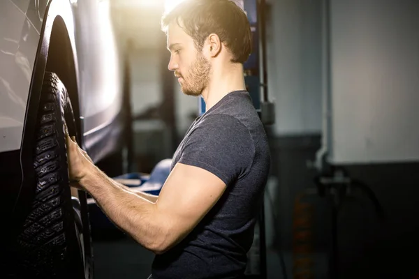 Mechanic adjusting tire wheel at repair garage