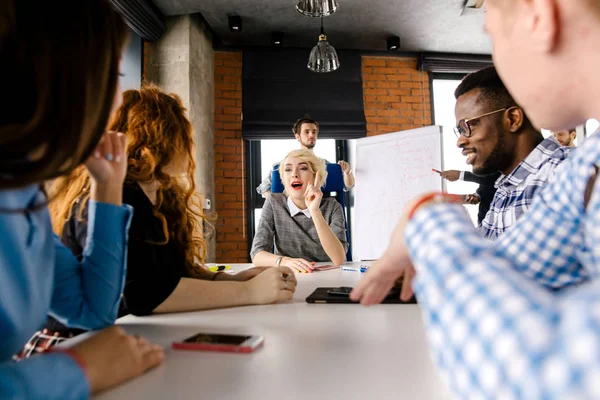 Beautiful chief with fair hair giving parting words to colleagues — Stock Photo, Image