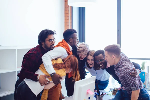 mixedrace startup team holding each other in a tender embrace