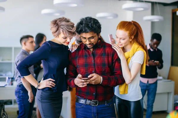 Confiante jovem indiano em roupas casuais inteligentes segurando telefone inteligente — Fotografia de Stock