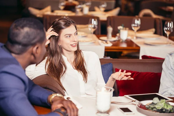 Gruppo di giovani che si incontrano al ristorante a cena — Foto Stock