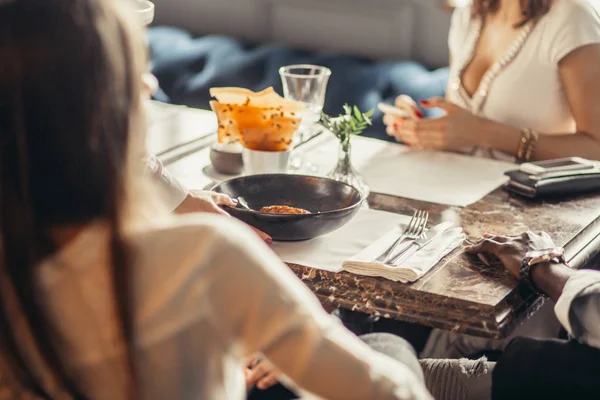 Grupo de amigos disfrutando de la comida en la cafetería — Foto de Stock