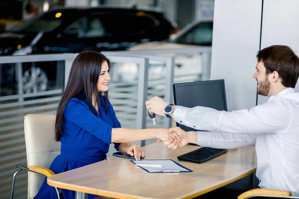 Venditore maschio e cliente femmina nell'ufficio vendita al dettaglio di automobili — Foto Stock