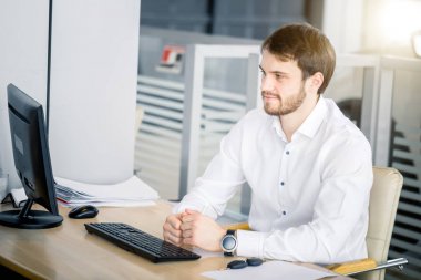 Ofiste masada oturan adam..