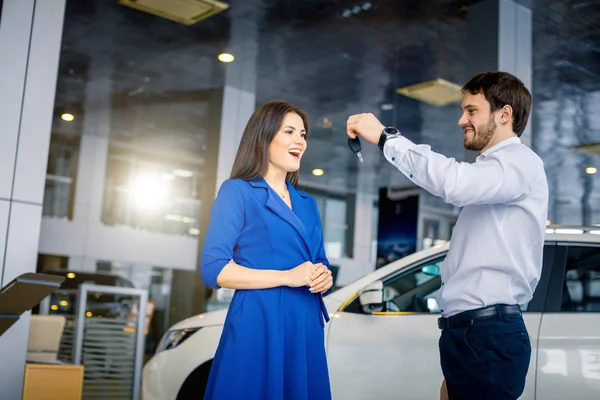 Boldog gyönyörű nő kap kulcsokat egy új autó auto bemutatóterem — Stock Fotó