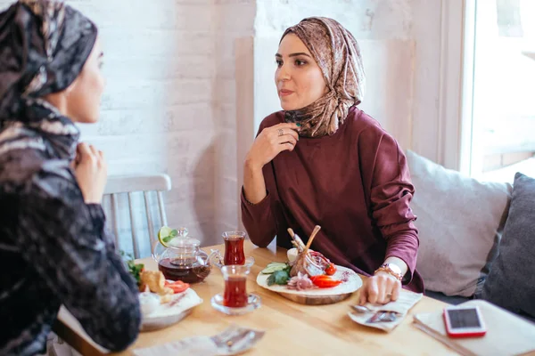Две мусульманки в кафе, встреча друзей — стоковое фото