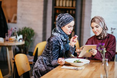 İki Müslüman kadın kafe, dükkan online elektronik tablet kullanma