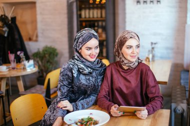 İki Müslüman kadın kafe, dükkan online elektronik tablet kullanma