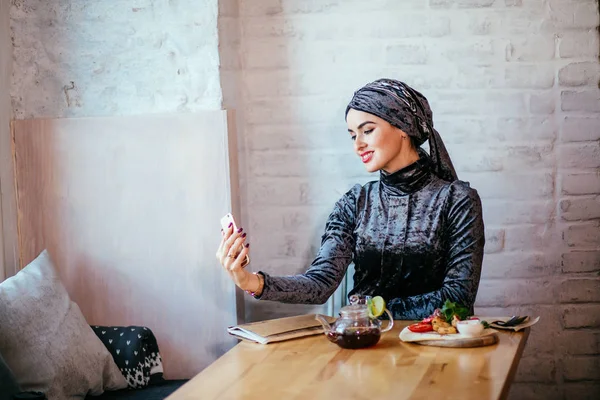 Mujer musulmana tomando selfie en la cafetería con smartphone — Foto de Stock