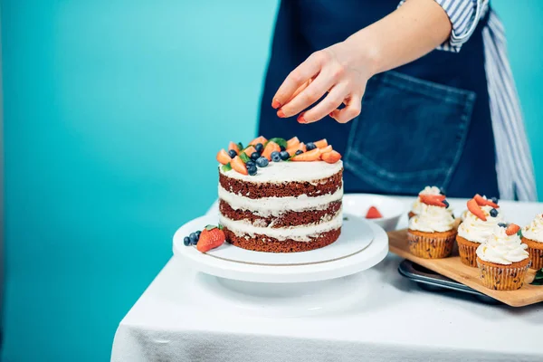 Mujer decoración delicioso pastel — Foto de Stock