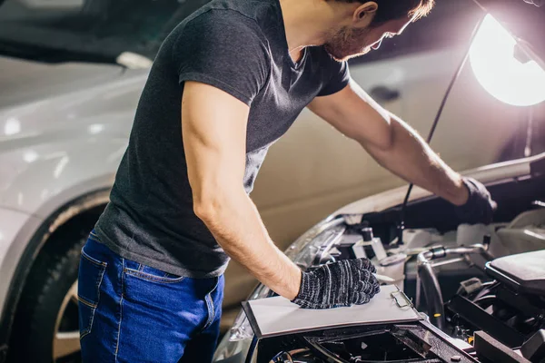 Exame mecânico sob o carro do capô e notas de escrita na garagem — Fotografia de Stock