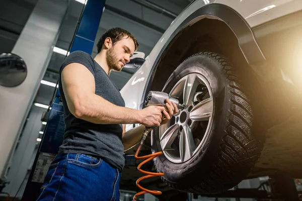 Mechanik se měnící auto kola v auto opravit garáž — Stock fotografie