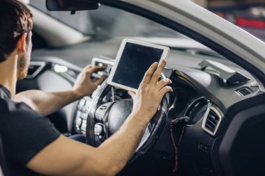 Mekanik oturan içinde araba arayan, dijital Tablet garajda