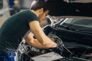 mekanik onarım garajda araba başlık altında çalışma