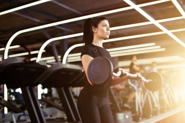 Fitness, genç bayana yaklaş. Beden eğitimi için pazılarını al.