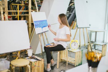 Kadın sanatçı resmini şövale onun atölyesinde yağlı boya ile resim