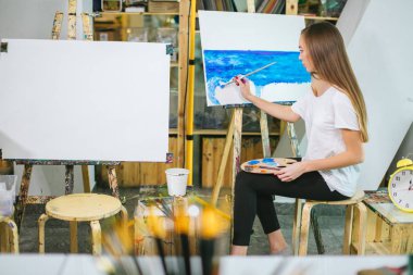 Kadın sanatçı resmini şövale onun atölyesinde yağlı boya ile resim