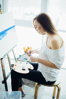 İyi aydınlatılmış bir stüdyoda resim boyama kadın sanatçı