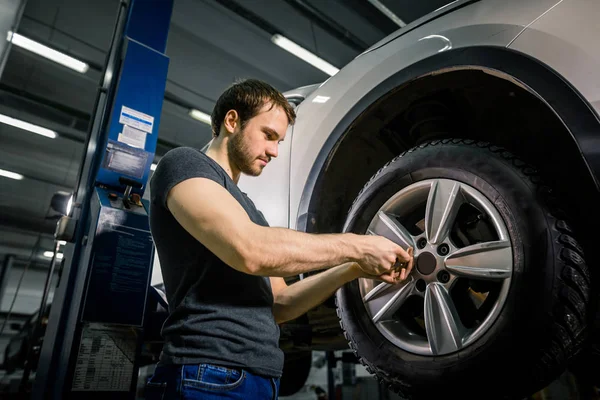 Změna pneumatik s ručním nástrojem v garáži evřít mechanik — Stock fotografie