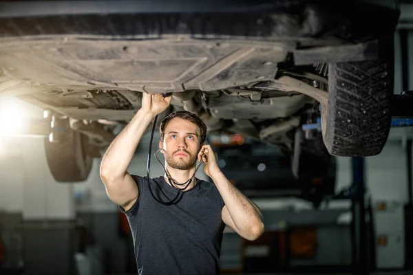 Technicus luisteren oude motor auto oren telefoons dokter — Stockfoto