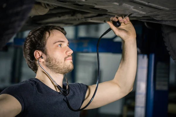 Técnico escuchar viejo motor coche oídos teléfono médico — Foto de Stock