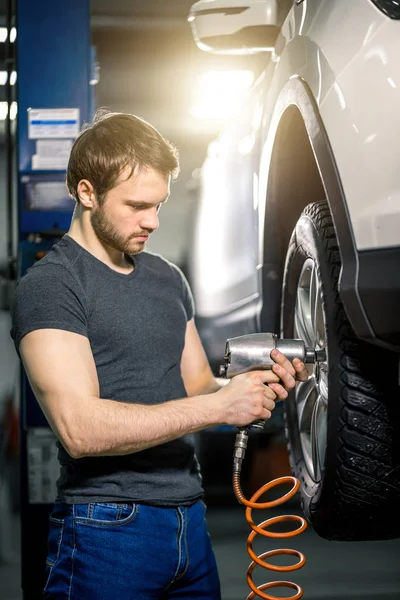 Механічна зміна автомобільного колеса в гаражі для ремонту автомобілів — стокове фото