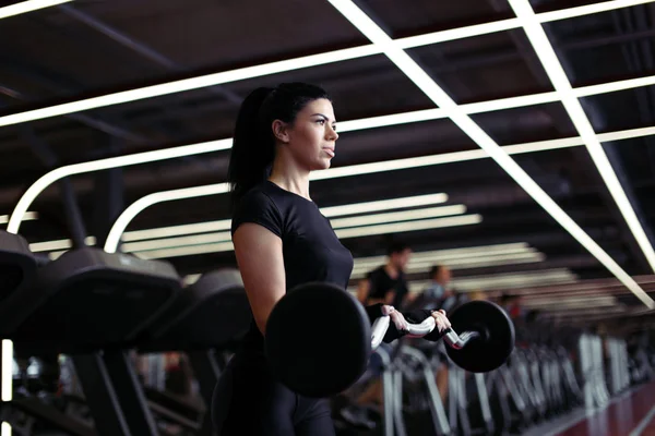 Фітнес, крупним планом молода жінка підбирає біцепси в спортзалі — стокове фото