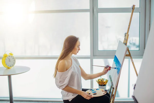 Pittore, ragazza europea che disegna paesaggi marini su tela nel suo laboratorio. Concetto di classi di belle arti — Foto Stock