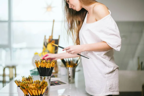 Natural beauty teacher painter in her studio preparing to an art class