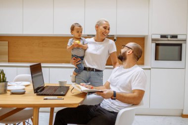 Babam evde, masada dizüstü bilgisayarla çalışıyor. Aile kavramı