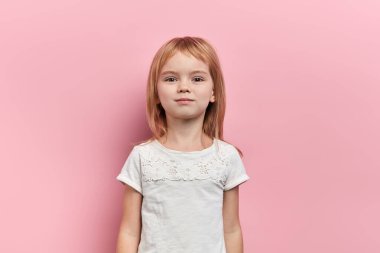 Sarışın, güzel küçük kız kameraya bakıyor.