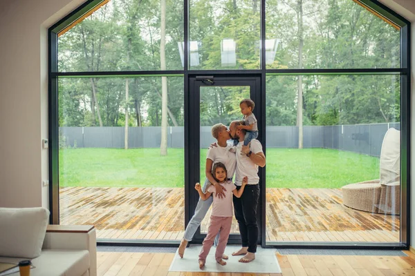 Femme avec son mari et deux chindren stand et regarder grande fenêtre panoramique — Photo