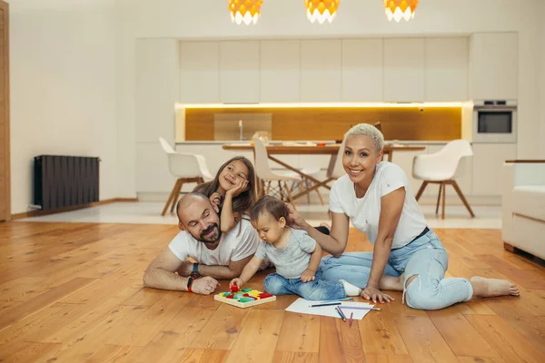 Biała rodzina. Rodzice z dziećmi bawią się i śmieją na podłodze — Zdjęcie stockowe
