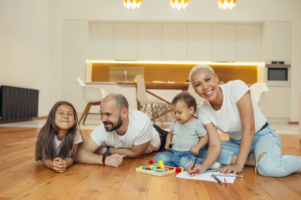 Happy family lying on floor in new countryhouse — Stock Photo, Image