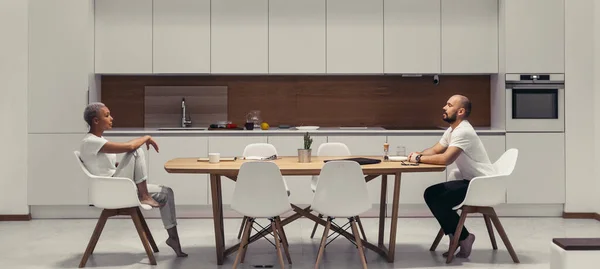 Europea familia pareja tener conversación mientras sentado en cocina mesa frente a otro — Foto de Stock