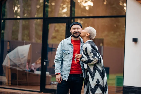 Casal atraente com sua nova casa no fundo — Fotografia de Stock