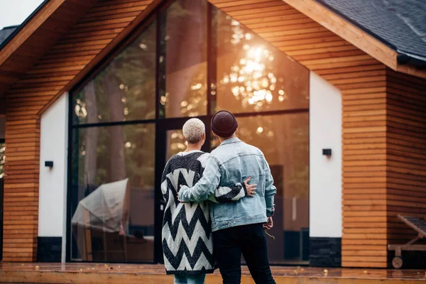Щаслива молода подружня пара дивиться на свій будинок — стокове фото