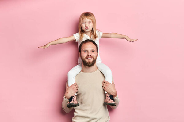 блондинка красивая девушка с вытянутыми руками отдыхает на плече отца
