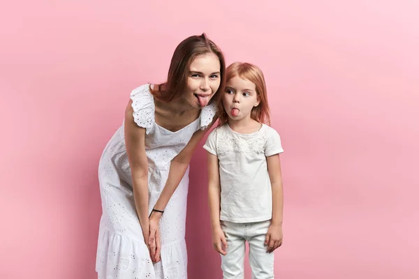 Primer plano retrato de descuidada madre divertida y su hija mostrando la lengua —  Fotos de Stock