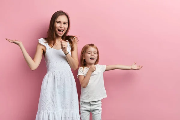 Aufgeregte, fröhliche Mutter und kleine Tochter genießen das Singen — Stockfoto