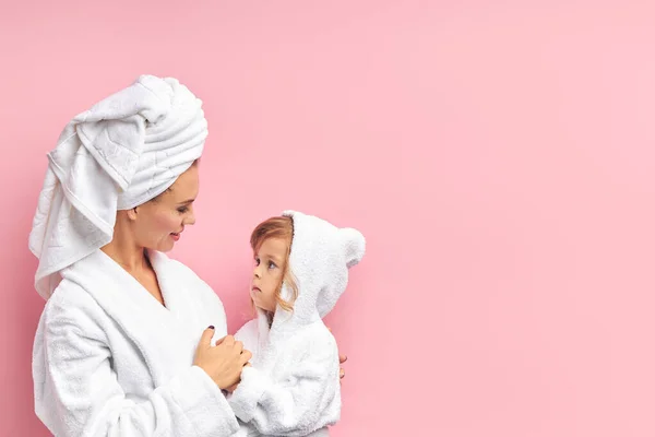 흰 수건으로 목욕 한 후귀여운 딸을 안고 있는 어린 어머니 — 스톡 사진